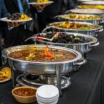 Elegant buffet display with various dishes served in warmers at a catered event.